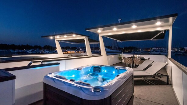 Ein Whirlpool auf einer Terrasse mit Blick auf Boote und einen Jachthafen.