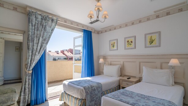A hotel room with two beds, a balcony, a chandelier, and framed floral artwork. - Exclusive Penthouse Luxury Resort Jurere Ilc2508 (Florianópolis)