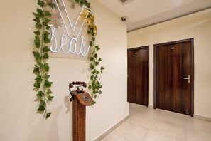 Um corredor com um letreiro de neon que diz 'seas', um telefone de madeira e duas portas de madeira.