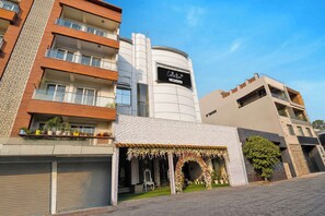 Un edificio de varios pisos con fachada moderna, un escaparate visible y una entrada con portón.