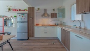 A modern kitchen with white cabinets, a built-in oven, and a stainless steel refrigerator. - unique flat_ garden and lagoon (Hurghada)