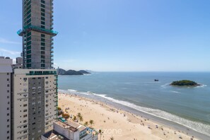 A beach with a high-rise building in the foreground and a small island in the distance. - Apart w/ Side Sea View in Front of Beach Iptr0241 (Balneário Camboriú)