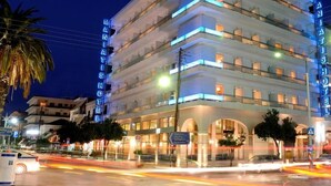Un hotel de varios pisos con un letrero llamativo en la esquina.