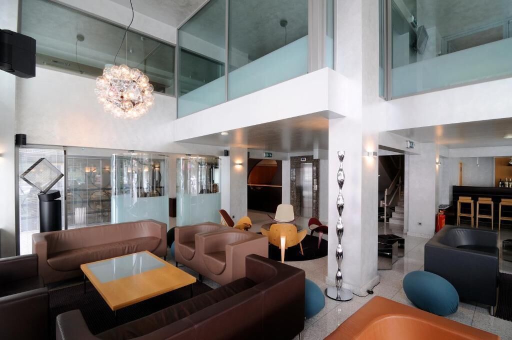 A modern interior with seating areas, a bar, and a staircase.