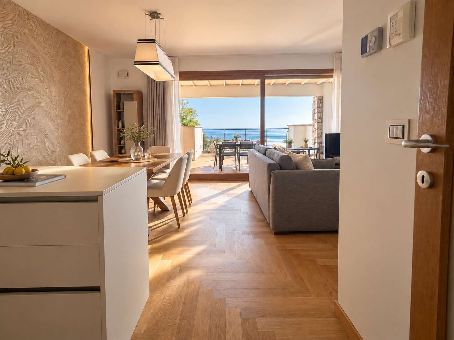 Un salon moderne avec un canapé, un coin repas et une vue sur la mer.
