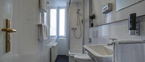 A modern bathroom with a shower, toilet, and sink.