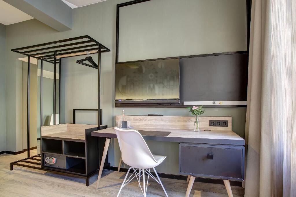 A modern bedroom with a bed, bedside table, and a large mirror.
