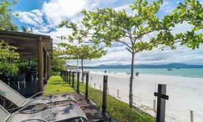 A beach view with lounge chairs, a wooden deck, and a clear sky. - Apt Foot in the Sand in Jurere Jbm201 (Florianópolis)