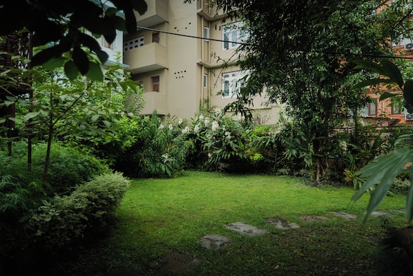 A well-maintained garden with a variety of plants and a lawn. - Mera Peak Hotel (Kathmandu)