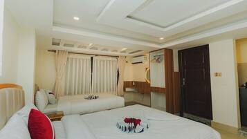 Habitación de hotel con dos camas, un armario de madera, un espejo y un equipo de aire acondicionado.