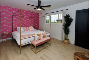 Ein Bett mit Baldachin, eine Bank, ein Blumentopf und ein Blick ins Freie durch ein Fenster.