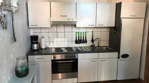 A modern kitchen with stainless steel appliances, a gas stove, a built-in oven, and a refrigerator. - Apartment '3-Wangerooge' with Wi-Fi (Dornum)