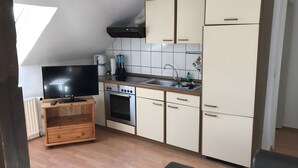 Ett kompakt kök med TV, ugn och diskho.