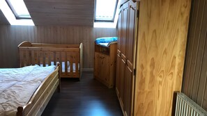 Ein Zimmer mit Etagenbett, Holzschrank und Dachfenster.