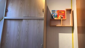 Eine Holztür mit Griff und einem Regal mit Büchern und einer kleinen Figur.