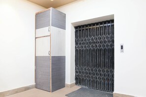 Un interior moderno con un mueble alto y estrecho y una reja de seguridad metálica.