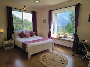 A bedroom with a bed, bedside tables, a desk, a chair, a window with curtains, and a view of greenery. - Hope Horizon Luxury villa by lexstays (Coonoor)
