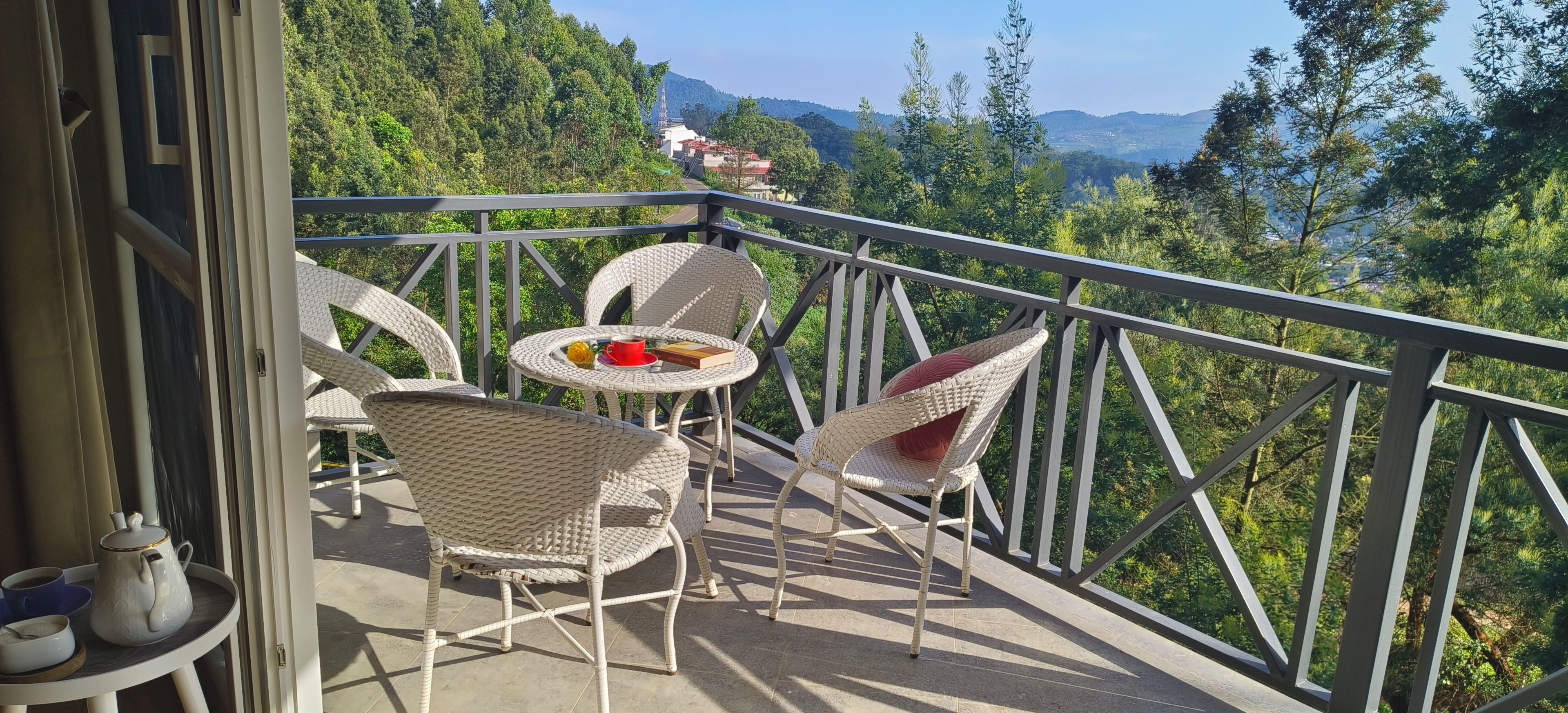 A balcony with wicker furniture, a table, and a cup of coffee.