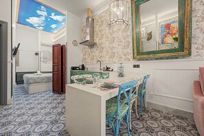 A kitchen with a dining area, a ceiling with a sky mural, and patterned floor tiles. - El Mar Azul 1 Beachfront Apartment, Wi-Fi, Air Conditioning (Torremolinos)