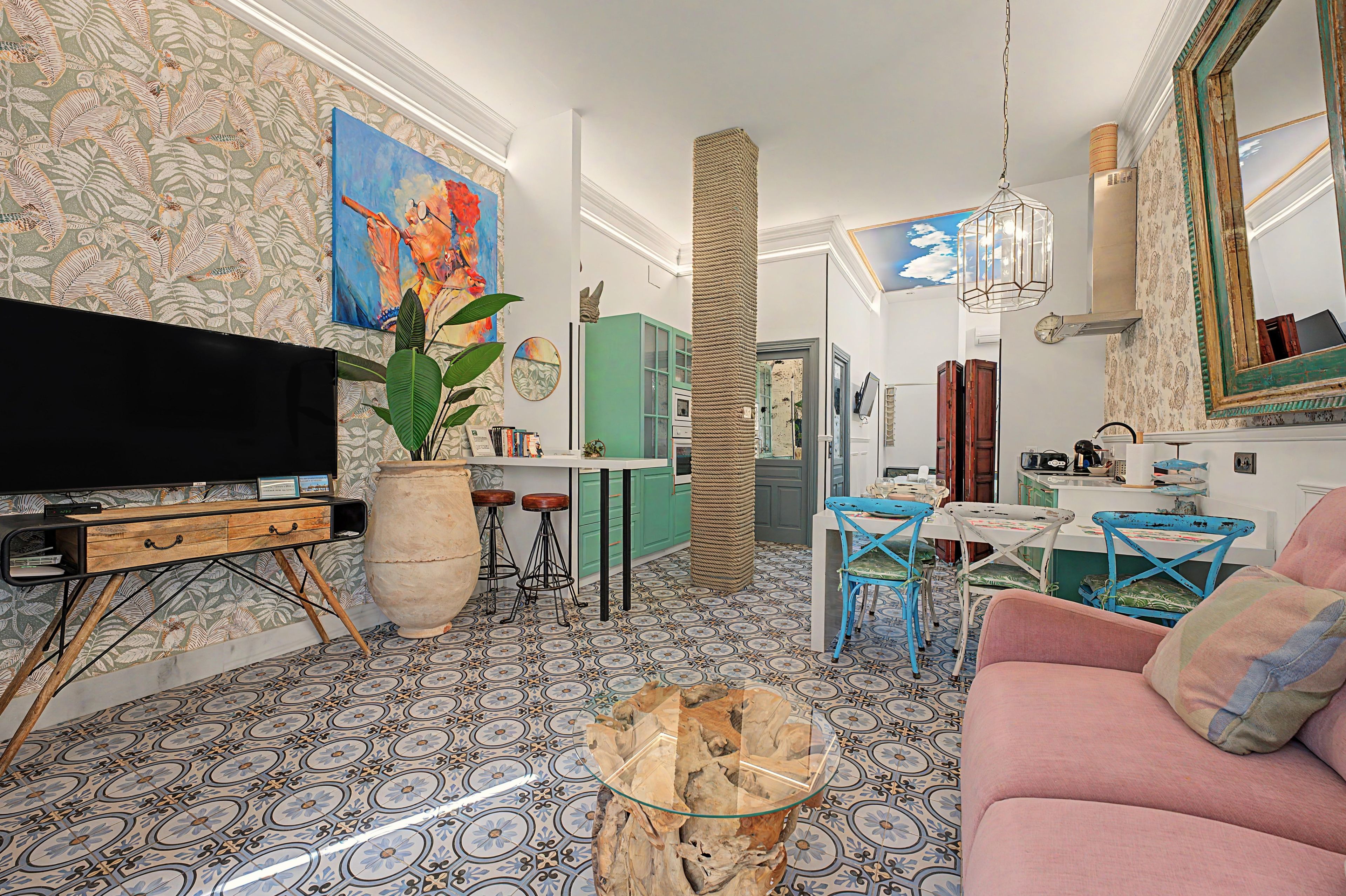 A living room with a television, a large potted plant, a coffee table, and a sofa.