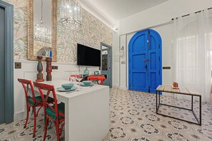 A dining area with a white table, red chairs, and a blue door in the background. - El Mar Azul 5 Beachfront Family Apartment (Torremolinos)
