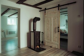 Ein Zimmer mit Kaminofen, Schiebetür und einem Bett.