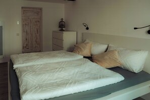 Ein Schlafzimmer mit einem Bett, einem Schminktisch, einem Kleiderschrank und einer Wandlampe.