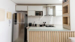 A modern kitchen with a stainless steel refrigerator, a microwave, and a gas stove. - Apartment in a Condominium in Setor Bueno Lhd0403 (Goiânia)
