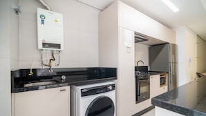 Uma cozinha moderna com máquina de lavar, forno e frigorífico embutidos.