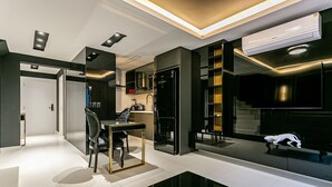A modern kitchen with built-in appliances, a dining area with a glass table, and a black entertainment unit. - Modern Duplex W/jacuzzi 240m Beach Jrr410 (Florianópolis)