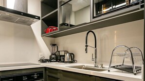 A modern kitchen with stainless steel appliances, a built-in oven, and a microwave. - Modern Duplex W/jacuzzi 240m Beach Jrr410 (Florianópolis)