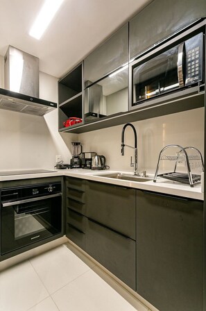 A modern kitchen with stainless steel appliances, a built-in oven, and a microwave. - Modern Duplex W/jacuzzi 240m Beach Jrr410 (Florianópolis)