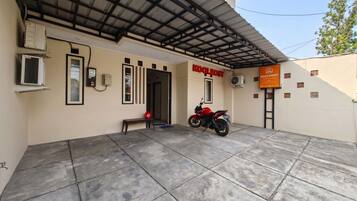 Um edifício com uma placa indicando 'KOOLKOST' e uma motocicleta estacionada na frente.