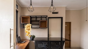 A modern kitchen with a wooden countertop, a black island, and pendant lighting.