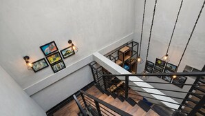 A multi-level interior with a staircase, wooden flooring, and wall-mounted lighting fixtures.