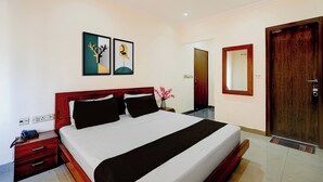 A hotel room with a bed, bedside table, lamp, artwork, and a door. - Collection O Bus Terminal Haldwani (Haldwani)