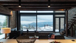 A modern interior with a large window offering a view of snow-covered mountains. - Heartbeat Mountain Escapes (Kato Sinikia Trikalon)