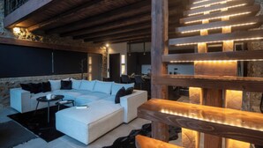 A modern living room with a sectional sofa, a coffee table, and a wooden bench. - Heartbeat Mountain Escapes (Kato Sinikia Trikalon)