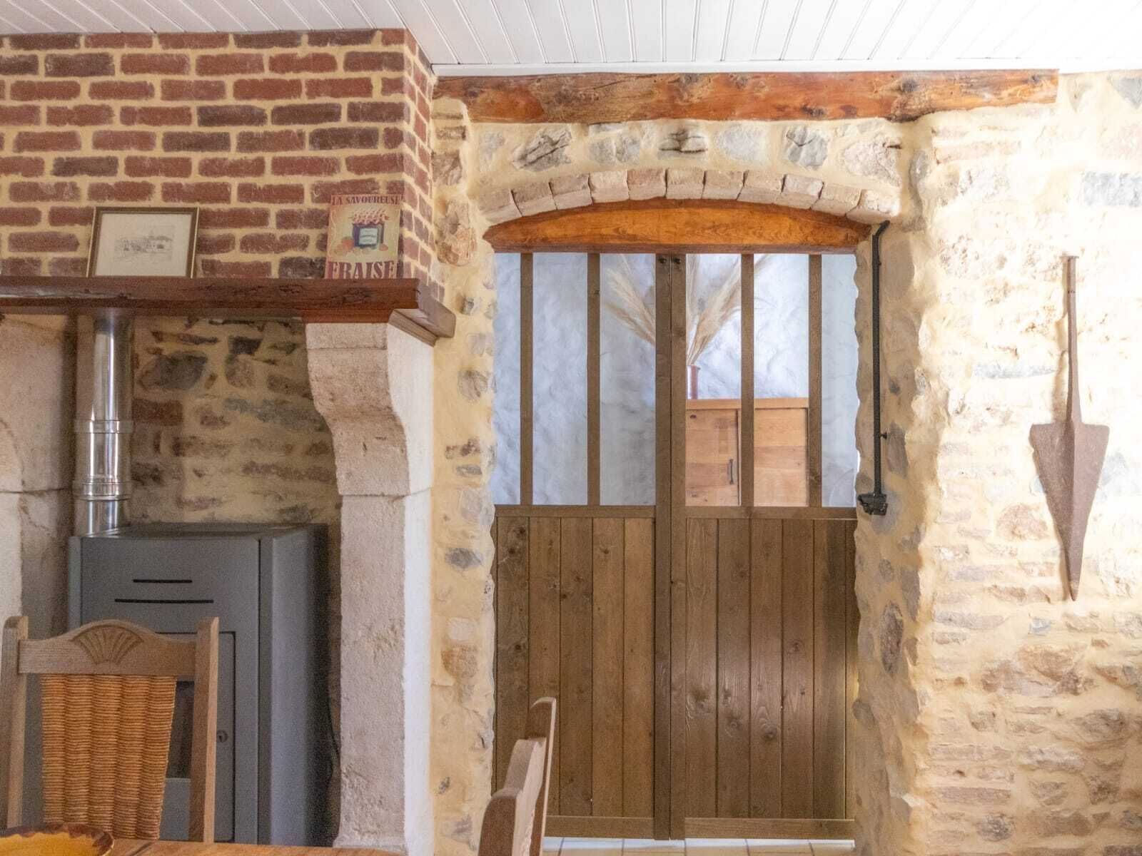 Ein rustikales Interieur mit einer Steinwand, einer Holztür und einem Kamin.