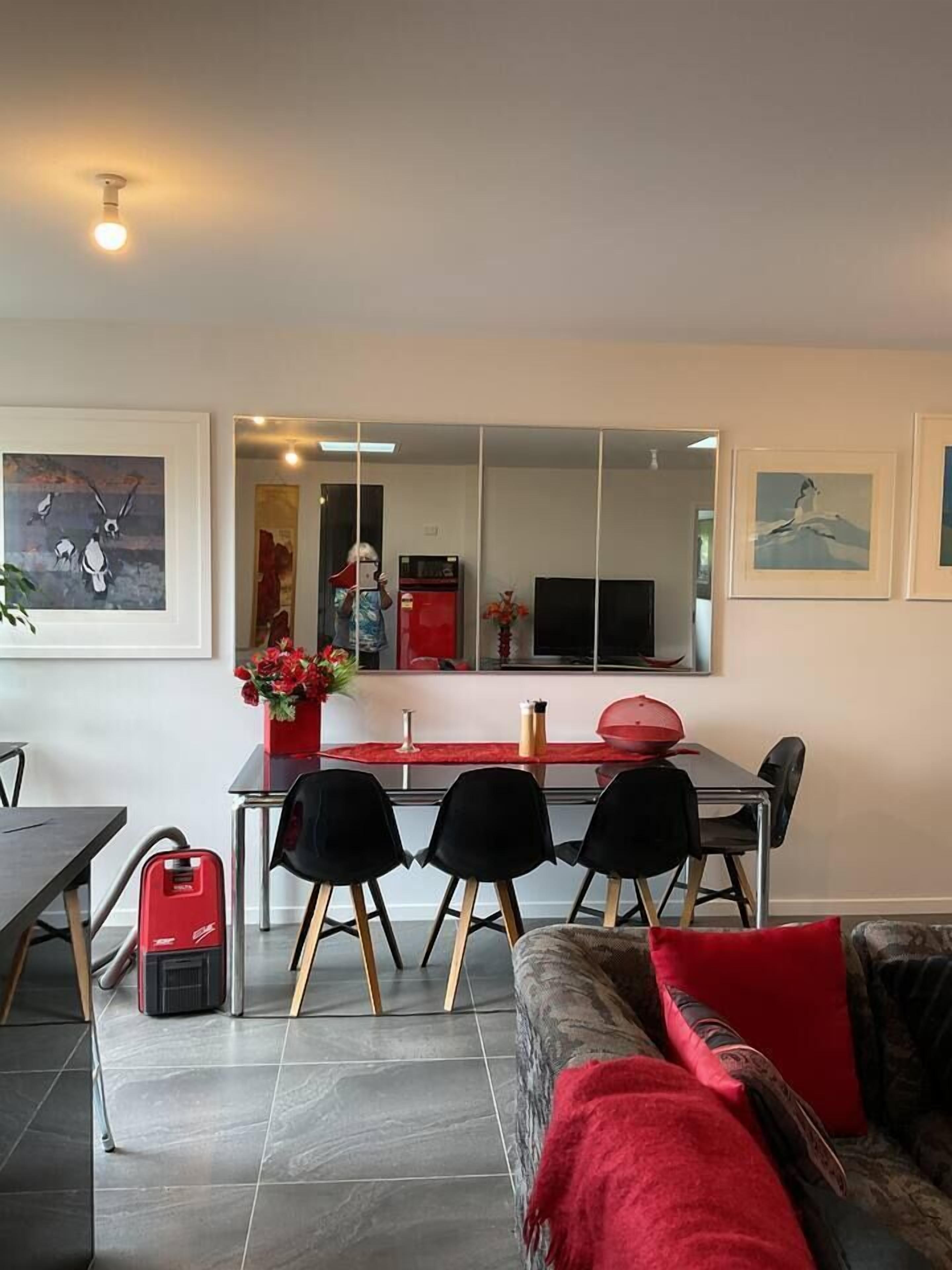 A modern living room with a sofa, a coffee table, and a dining area with chairs and a table.