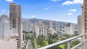 A cityscape with high-rise buildings, a clear sky, and a road with vehicles.
