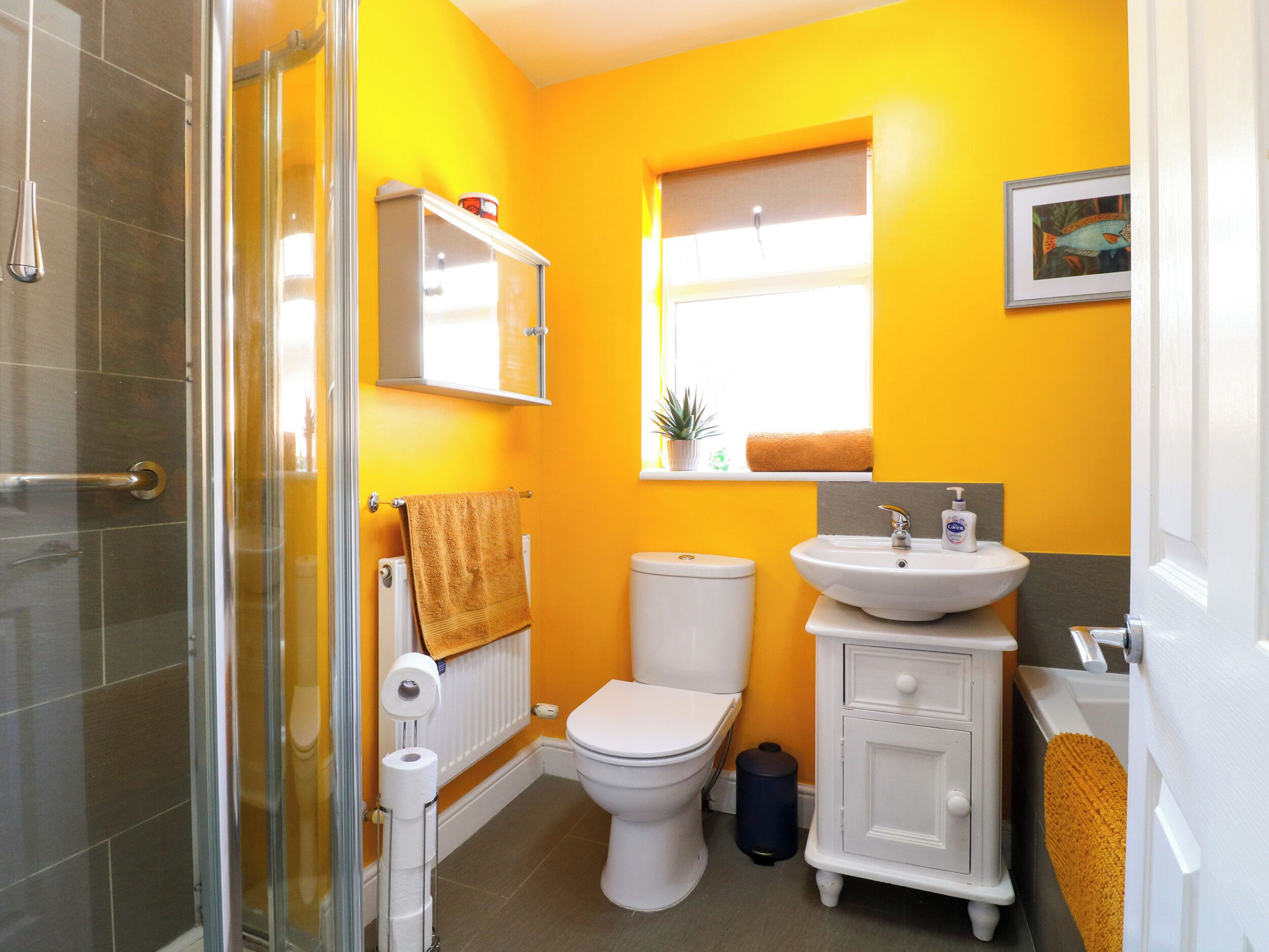 Une salle de bain comprenant des toilettes, un lavabo et un espace douche.