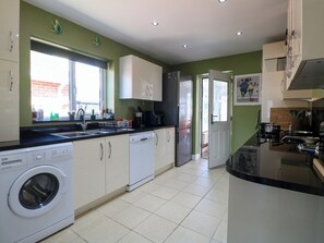 A modern kitchen with a washing machine, dishwasher, and a refrigerator. - Pinecote Cottage (Nottingham)