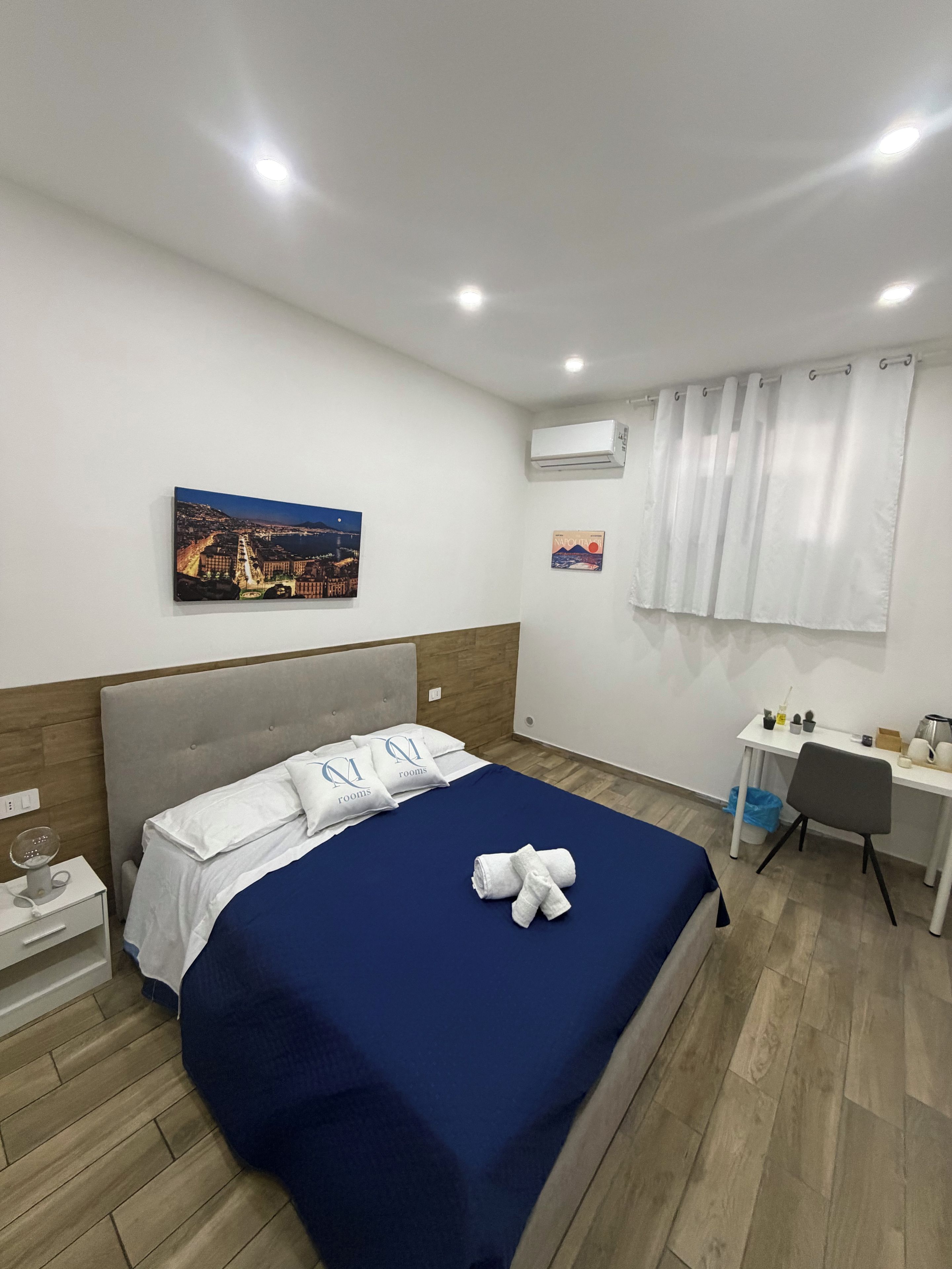 A hotel room with a bed, a desk, and a chair.
