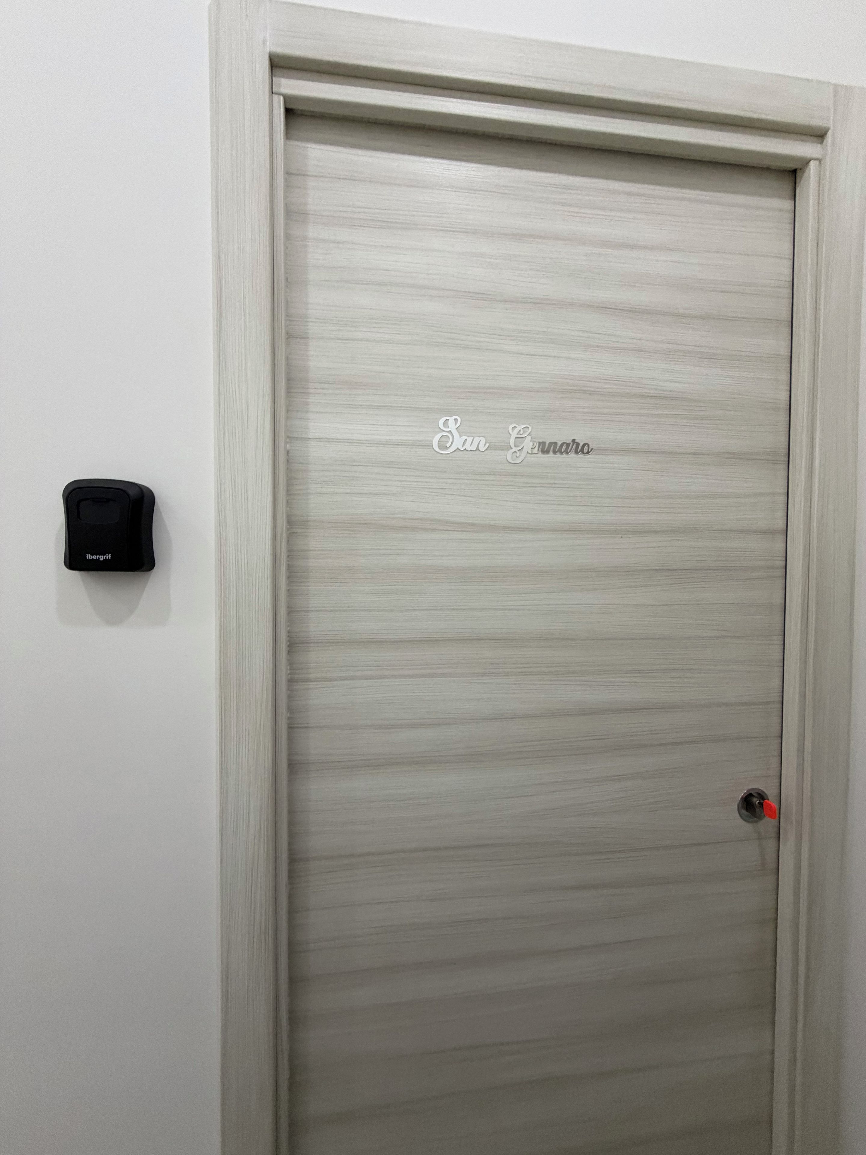 A door with a textured surface and a nameplate reading 'San Giovanni'.