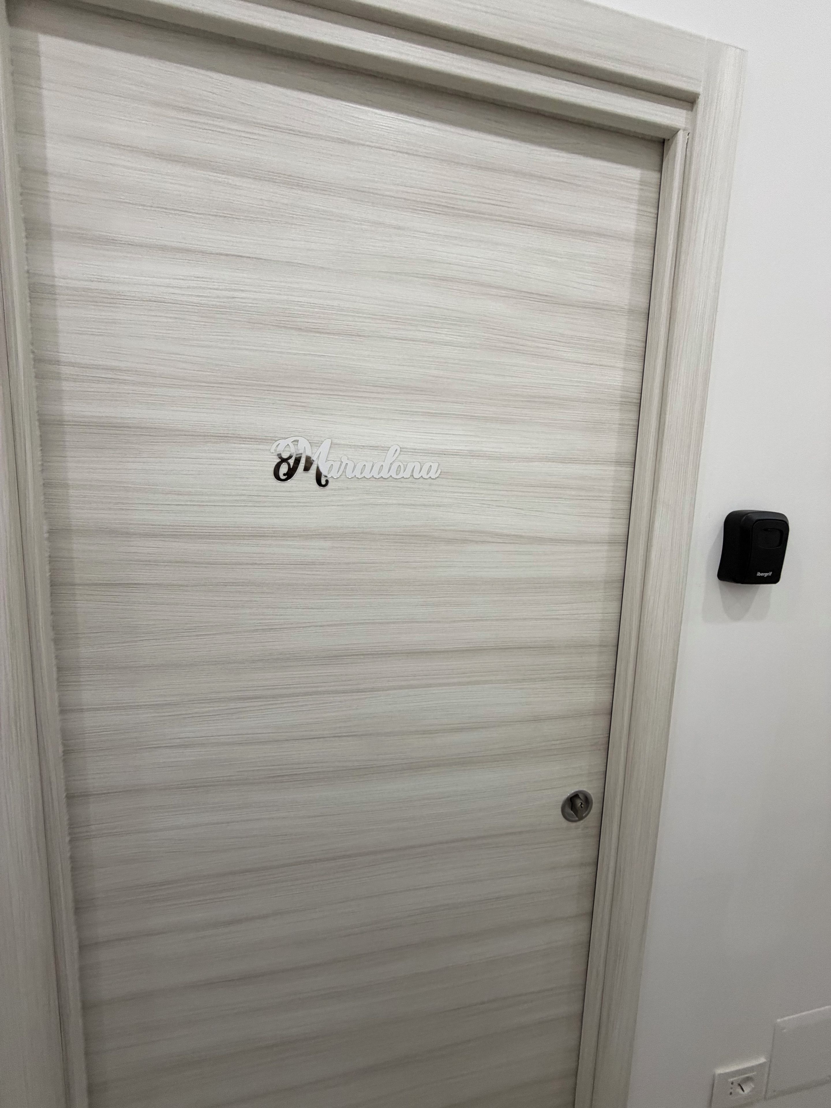 Une porte fermée, dotée d’une surface texturée et d’un petit logo au centre.