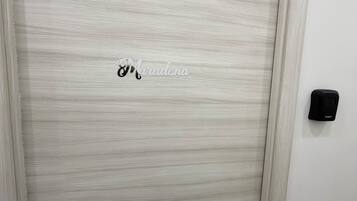 Une porte fermée, dotée d’une surface texturée et d’un petit logo au centre.