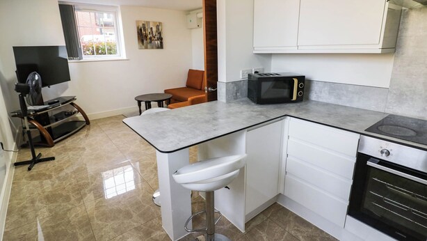 A compact kitchen with a built-in microwave, a stove, and a sink.