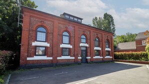 A red brick building with arched windows and a flat roof, labeled as '1898 Pump House.'