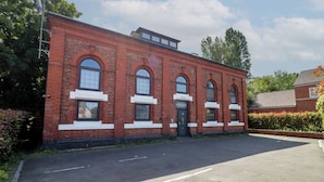 A red brick building with arched windows and a flat roof, labeled as '1898 Pump House.'